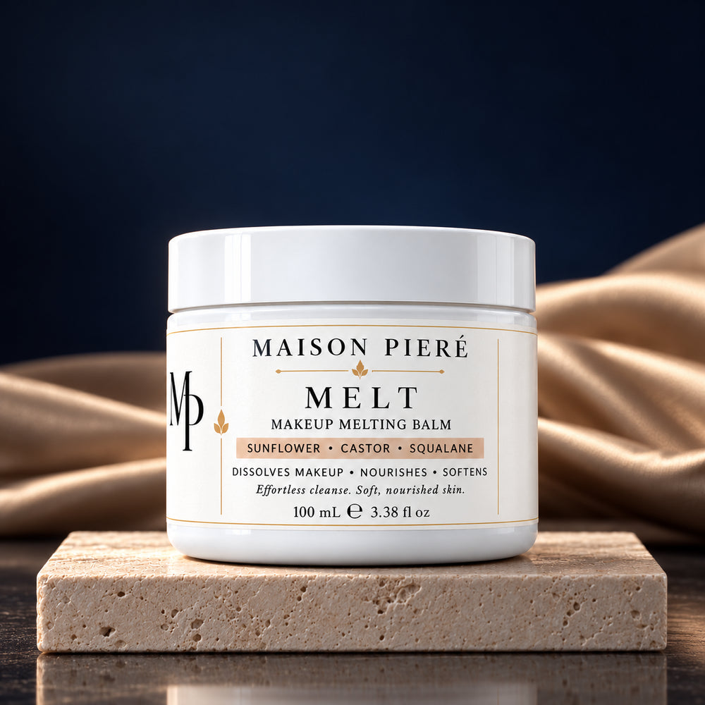 MELT makeup melting balm, 100 mL, on ivory stone with champagne fabric and a midnight-blue background